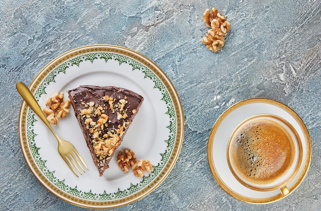 Torta al cioccolato con pere e noci sul piatto con una tazza di caffè Piatto lay