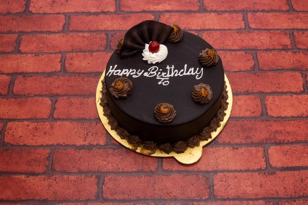 Torta al cioccolato con scritta di buon compleanno servita in un piatto isolato sullo sfondo vista superiore del dessert del Bangladesh
