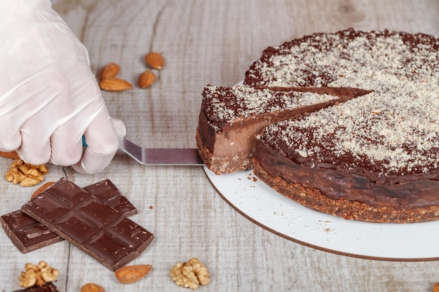 Torta al cioccolato con un pezzo tagliato e lama su sfondo grigio primo piano