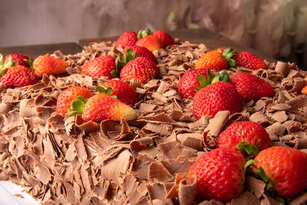 Torta al cioccolato, dettagli di una bella torta al cioccolato con fragole, sfondo astratto, messa a fuoco selettiva.