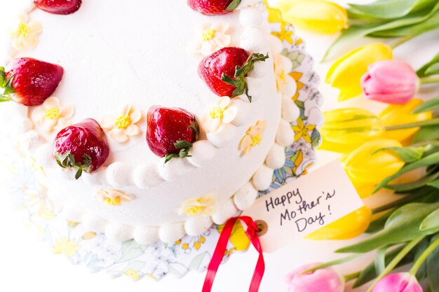 Torta al cioccolato e limone, fragole, composta da 6 strati di torta al cioccolato, farcita con lemon curd e mousse alla fragola, ricoperta di glassa al cioccolato bianco.