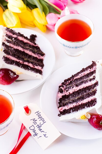 Torta al cioccolato e limone, fragole, composta da 6 strati di torta al cioccolato, farcita con lemon curd e mousse alla fragola, ricoperta di glassa al cioccolato bianco.