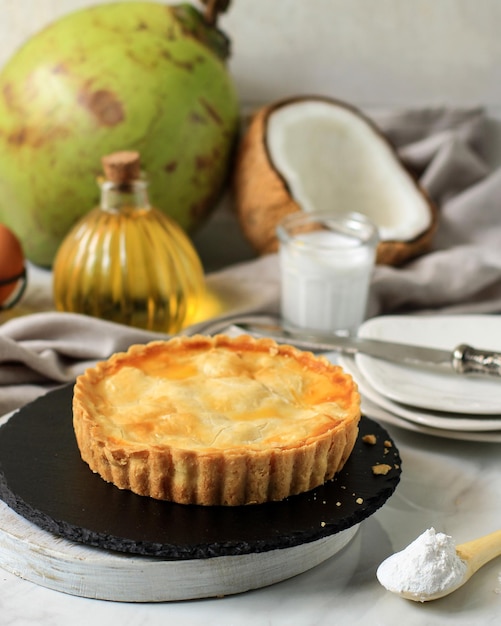 Torta al cocco rotonda fatta in casa. A base di burro e farina e farcito con polpa di cocco giovane al centro. Servire su Piatto Rotondo in Pietra