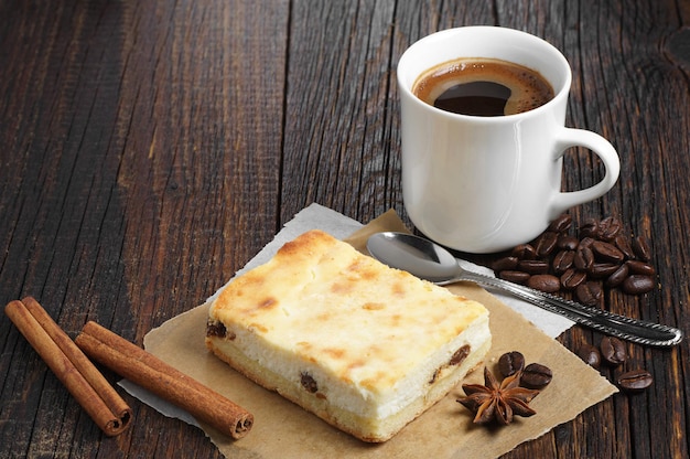 Torta al formaggio con una tazza di caffè caldo sul tavolo di legno scuro