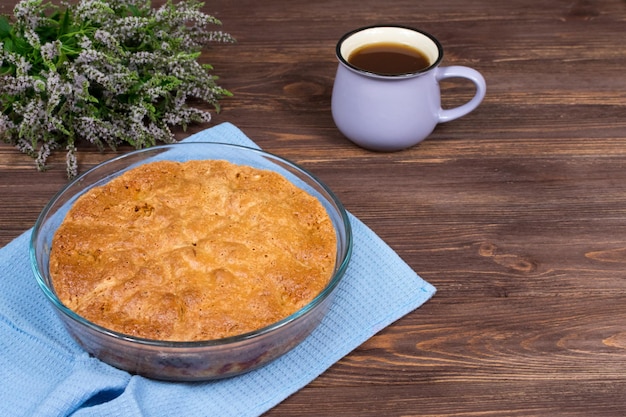 Torta al forno fresca su una superficie di legno scuro con una tazza di tè e fiori di tiglio Posto per un'iscrizione