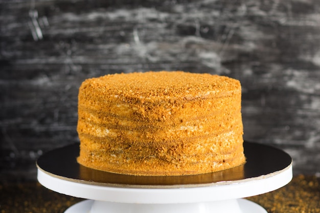 Torta al miele cosparsa di briciole su sfondo nero