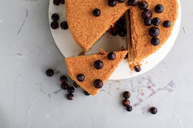 Torta al miele ritaglia un pezzo con i mirtilli sopra