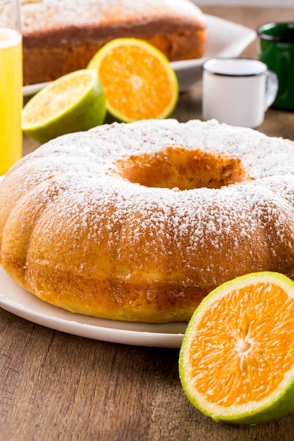 Torta all'arancia sul tavolo con frutta e succhi.