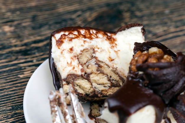 Torta alla crema ricoperta di cioccolato con pan di spagna, torta a forma di cubo su un piatto