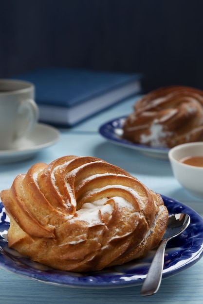 Torta alla crema su un piattino blu con caffè