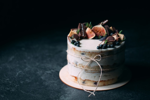 Torta alla frutta decorata con fichi, biscotti e mirtilli.