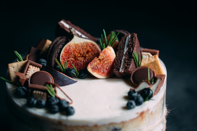 Torta alla frutta decorata con fichi, biscotti e mirtilli.