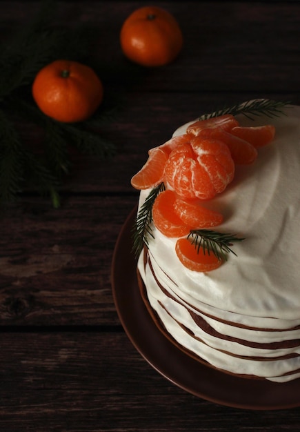 Torta alta al cioccolato multistrato fatta in casa con crema bianca e mandarini