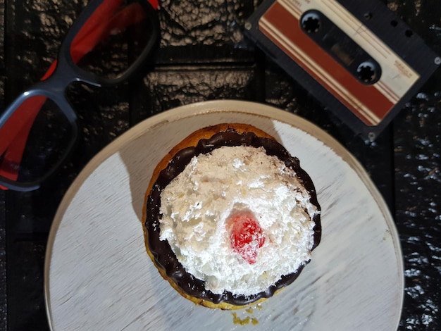 Torta appetitosa con crema al cioccolato e pasta decorata con ciliegie sfondo nero incolla lo spazio della copia