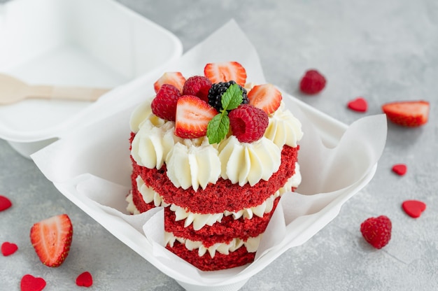 Torta bento di velluto rosso Piccola torta in un cestino per il pranzo su uno sfondo di cemento grigio Torta di San Valentino