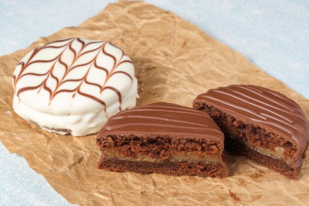 Torta brasiliana al miele tagliata a metà una accanto all'altra con glassa di cioccolato bianco su carta marrone