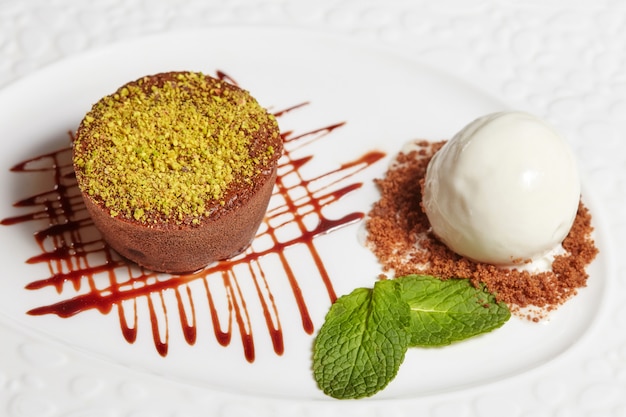 Torta brownie al cioccolato con gelato alla vaniglia sul piatto bianco