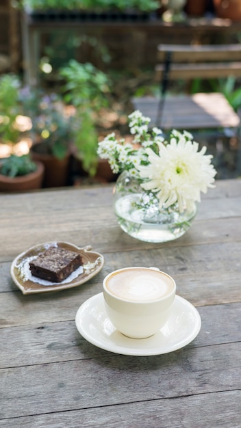 Torta calda del brownie e del caffè su una tabella di legno.