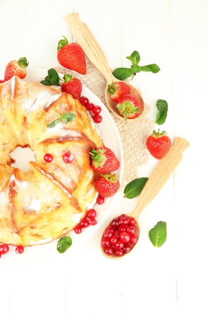 Torta casalinga saporita con le bacche sulla tavola di legno bianca