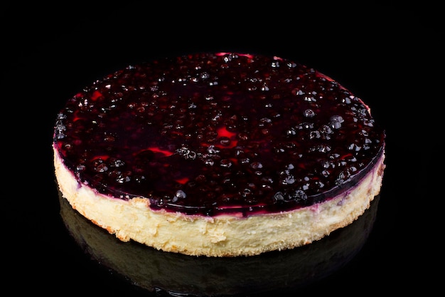 Torta cheesecake con ciliegie in gelatina su sfondo nero