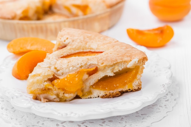 Torta con albicocche fresche su un piatto bianco