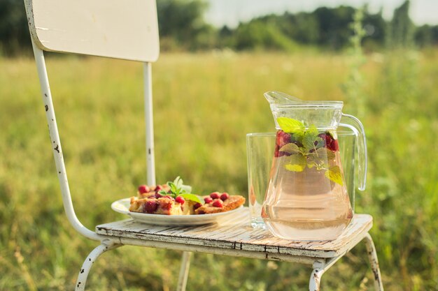 Torta con frutti di bosco e brocca con bevanda alla menta fragola