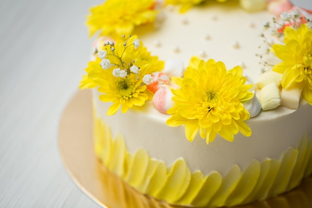 Torta con macchie gialle, crisantemi gialli e meringa