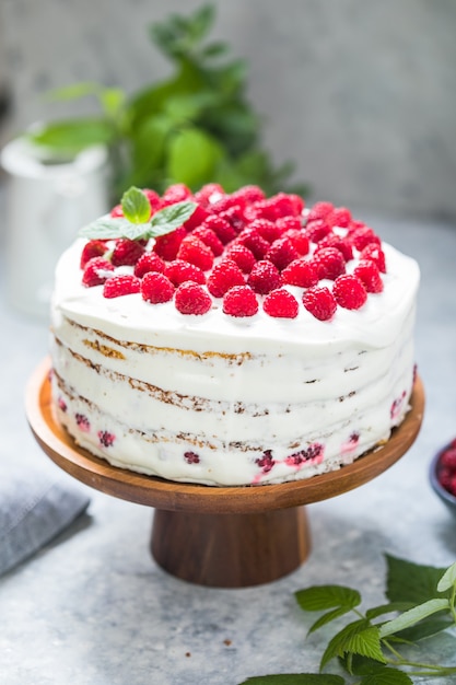 Torta con mousse di crema e farcitura di lamponi su supporto tondo