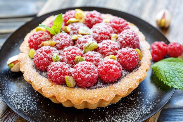 Torta con pistacchi al cioccolato e lamponi freschi