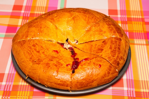 Torta con ribes rosso tagliato a pezzi sul primo piano del tavolo