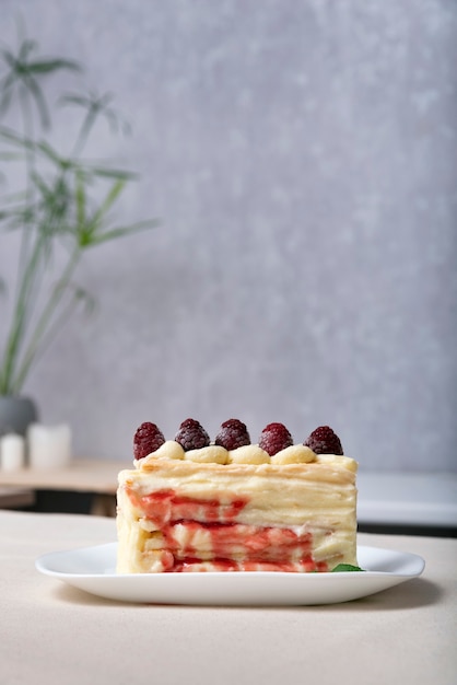 Torta con sciroppo di frutti di bosco guarnita con lamponi. Pezzo di torta alla frutta.