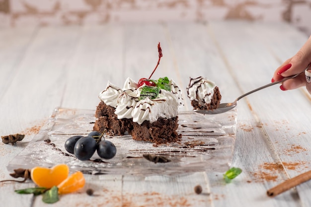 Torta cremosa dolce con frutta su fondo di legno bianco