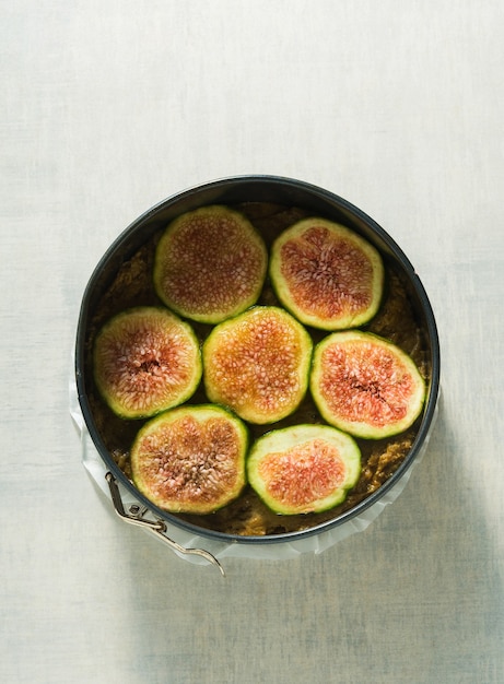 Torta cruda con fichi in una teglia, pronta per essere cotta in forno