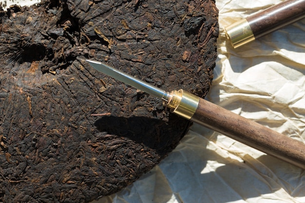 Torta da tè Pu-erh e coltello per la cerimonia del bere.