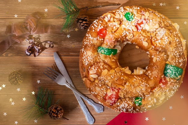 Torta dell'Epifania Roscon de Reyes con frutta candita su un tavolo di legno Dolce tipico spagnolo