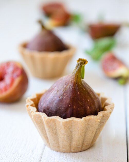 Torta della tazza della frutta del fico sui bordi di legno chiari. Messa a fuoco selettiva