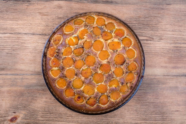 Torta di albicocche biologica fatta in casa dessert pronto da mangiare Crostata di albicocche con noce su sfondo di legno primo piano vista dall'alto