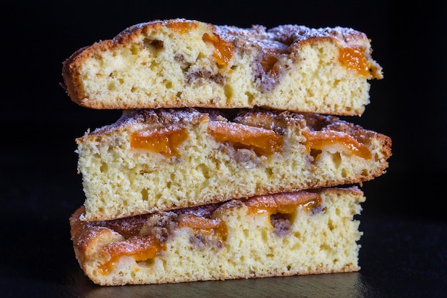 Torta di albicocche biologiche fatte in casa dessert pronto da mangiare Crostata di albicocche con noce su sfondo nero primo piano