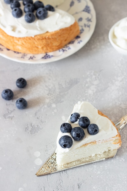 Torta di angelo cibo con panna montata e mirtilli freschi.