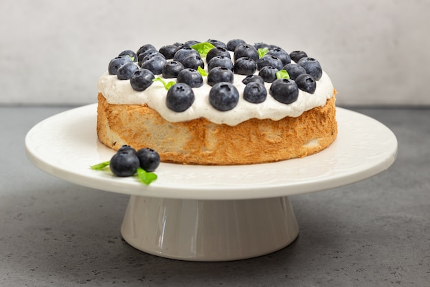 Torta di angelo cibo con panna montata e mirtilli.