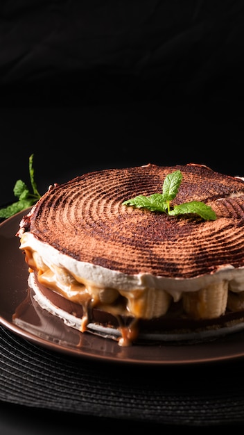 Torta di banoffee casalinga di concetto del dessert dell&#39;alimento su fondo nero