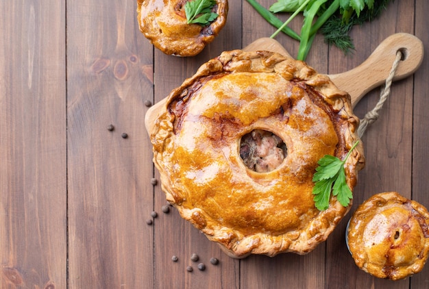 Torta di carne fatta in casa con verde su sfondo di legno