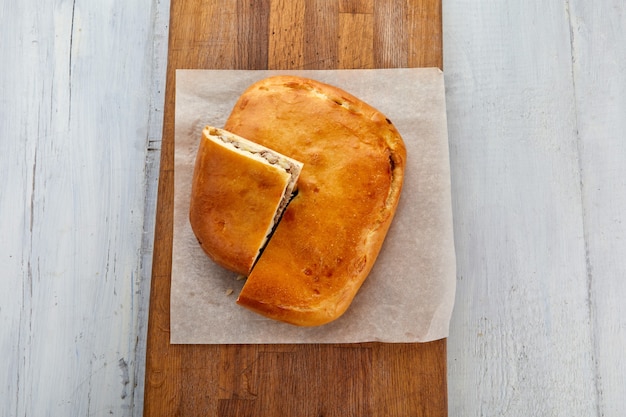 Torta di carne sul fondo di legno bianco del tagliere