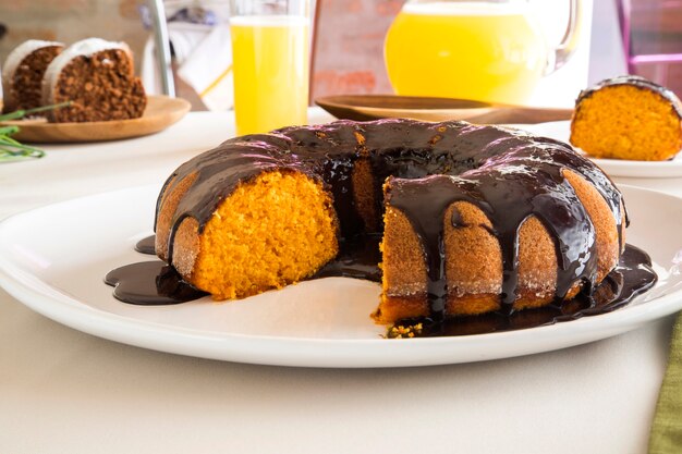 Torta di carote con cioccolato e fetta sul tavolo.