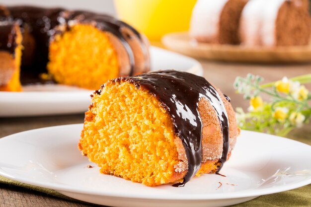 Torta di carote con cioccolato e fetta sul tavolo.