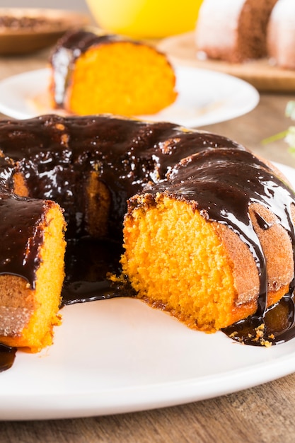 Torta di carote con cioccolato e fetta sul tavolo.