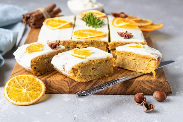 Torta di carote crude con glassa di crema di formaggio, fette d'arancia essiccate e spezie (cannella e anice).