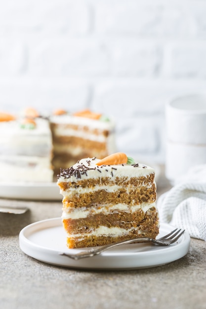 Torta di carote fatta in casa sana con glassa di formaggio cremoso su pietra chiara