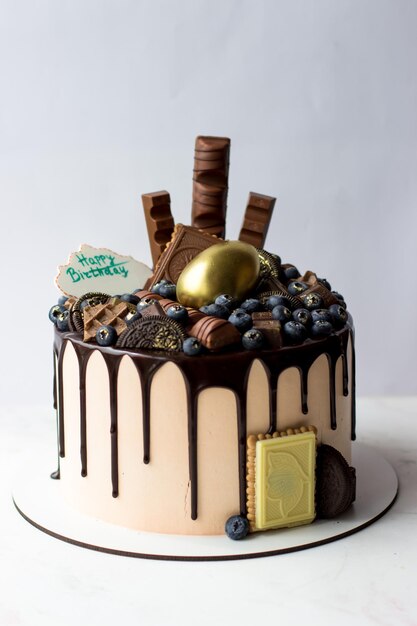 Torta di compleanno decorata con cioccolato e caramelle Buon compleanno