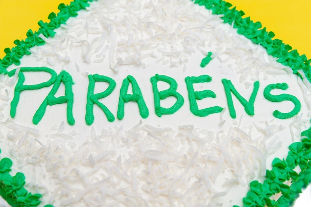 Torta di compleanno decorata con glassa verde e cocco grattugiato